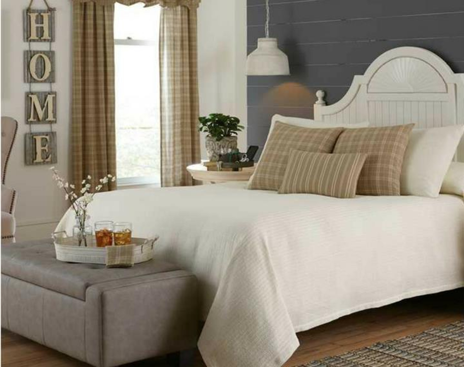 Bed with modern white bedding in the corner of a bedroom