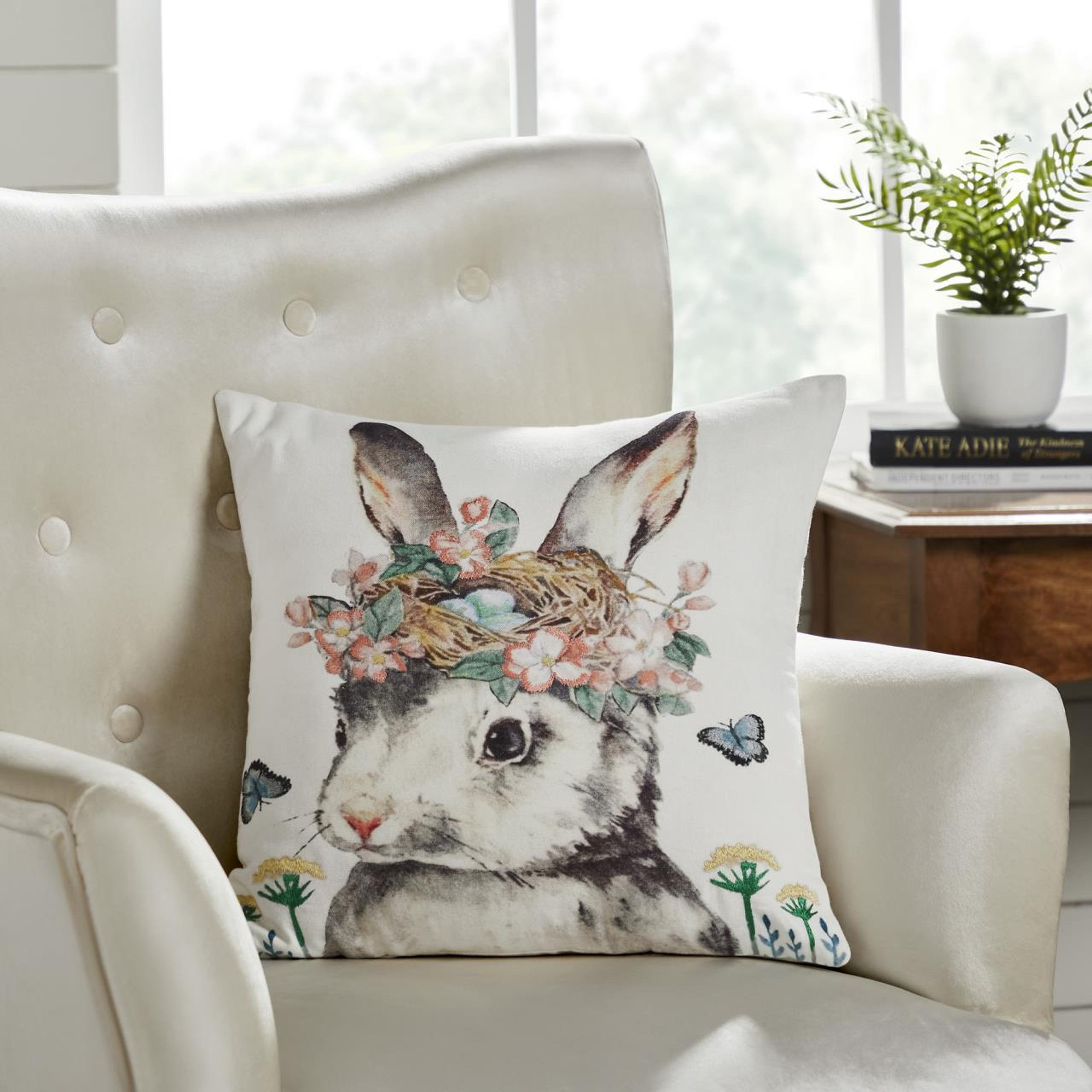 Garden bunny throw pillow on a white armchair