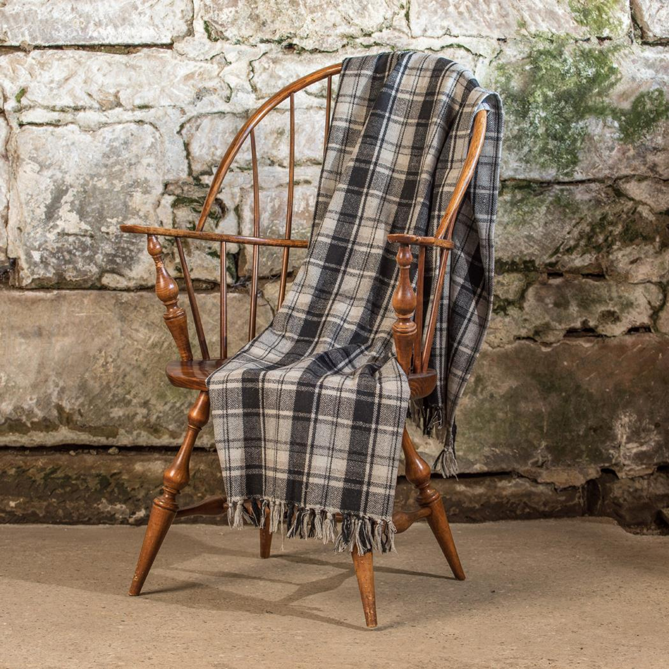 Plaid throw blanket over a wooden chair