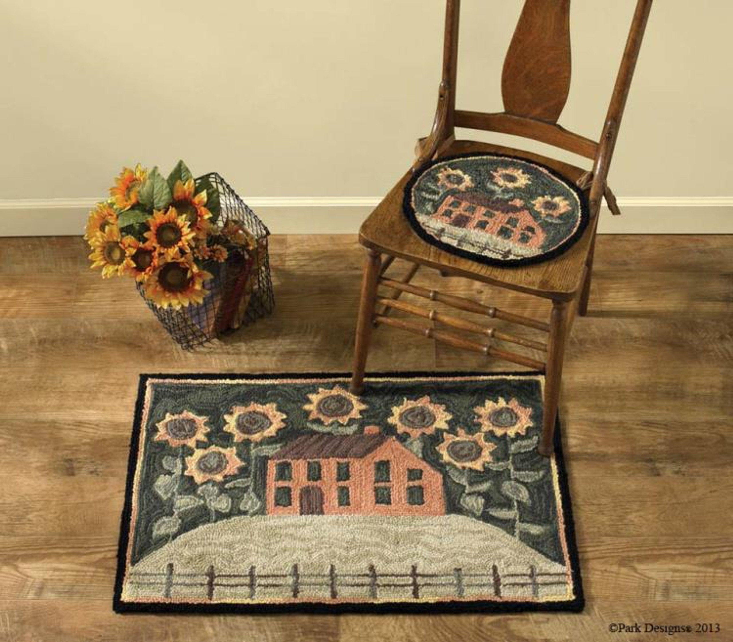 House and sunflower rug next to a chair and basket of sunflowers