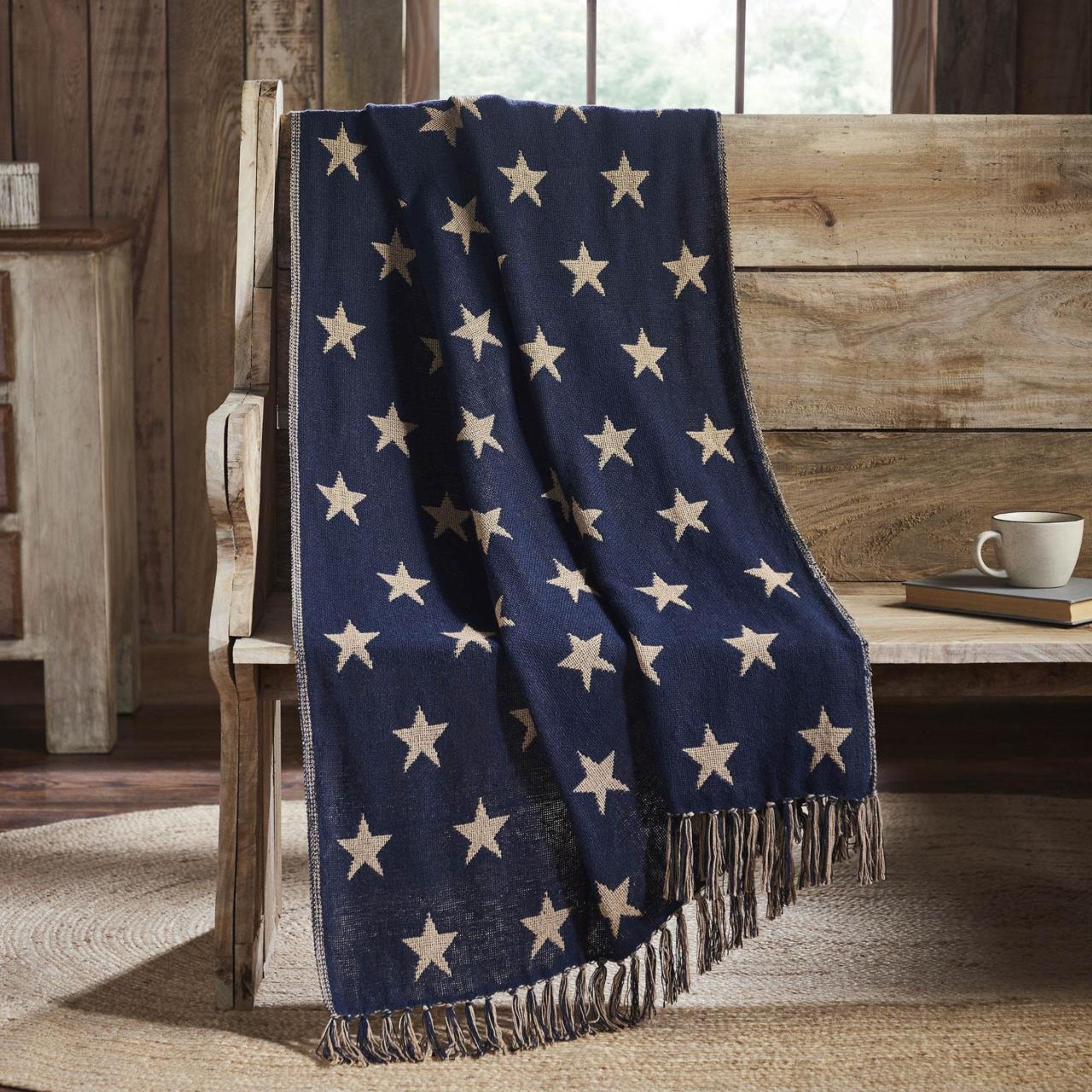 Blue woven star throw blanket draped over a wooden bench