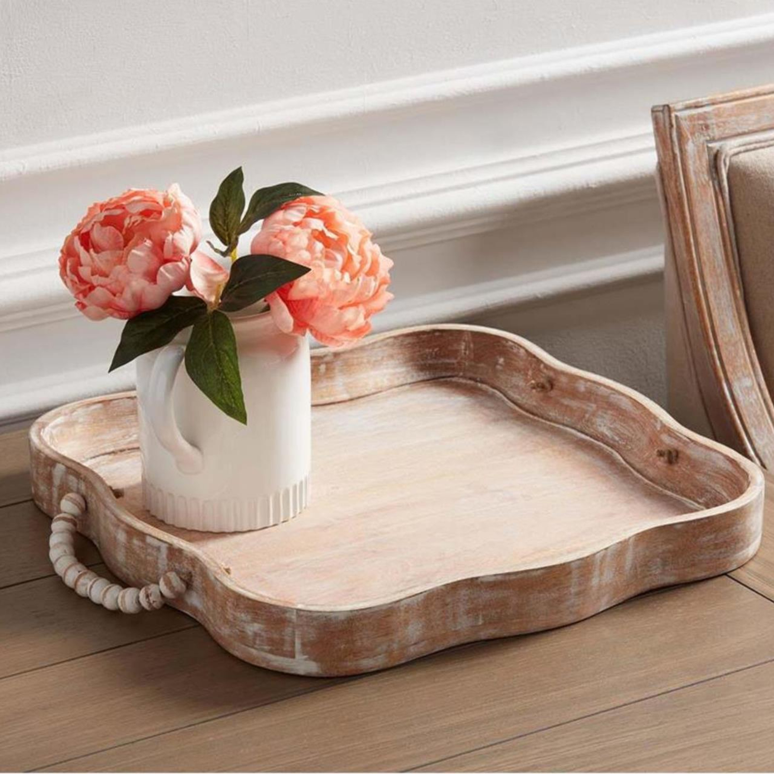 Vase with fake flowers on a wooden tray
