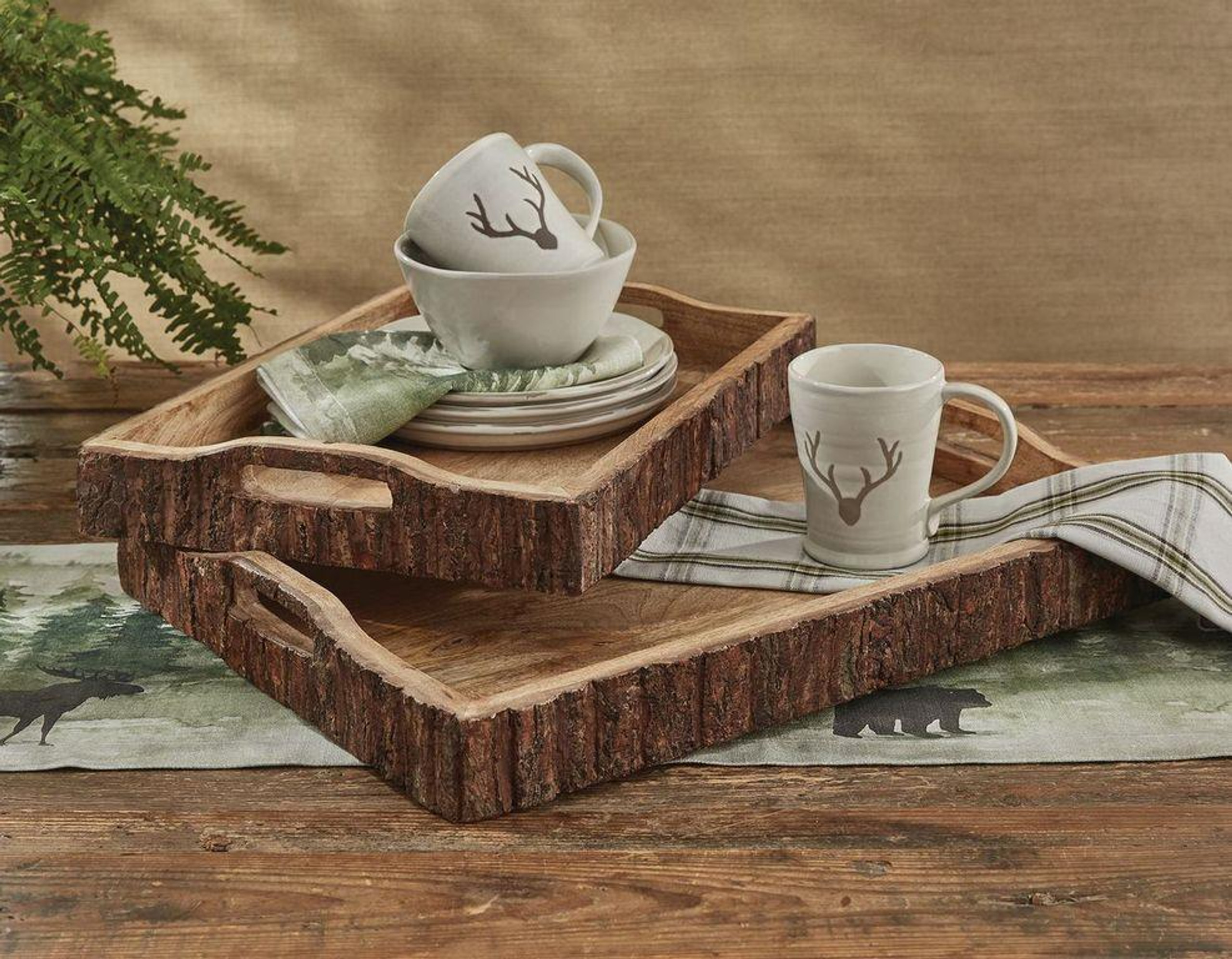 Mugs, plates, and napkins on top of a set of wooden trays